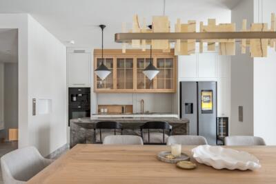 Modern kitchen with a wooden table and an elegant fridge.