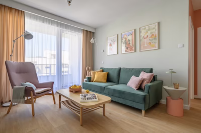 Cosy living room with a green sofa and pastel accessories.