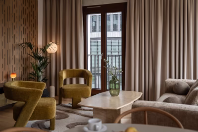 Stylish living room with mustard armchairs, wooden panels and plants.