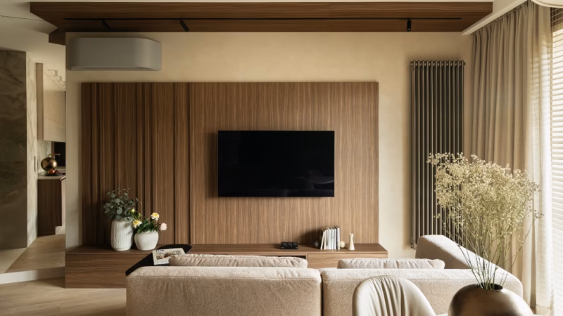 Living room with a television on a wood-toned panel and a beige sofa.