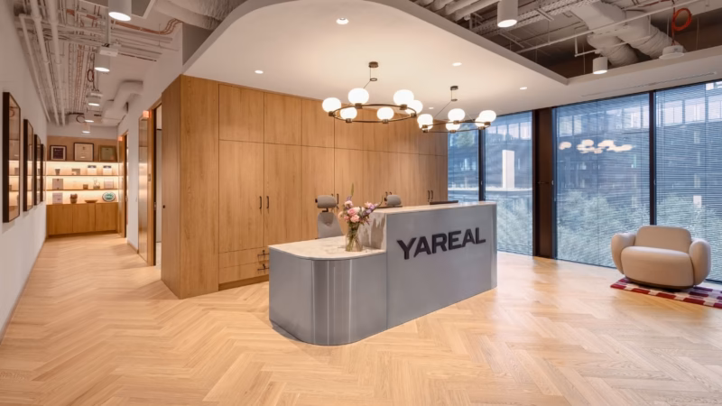 Office reception area with wooden fittings and a curved counter by YAREAL