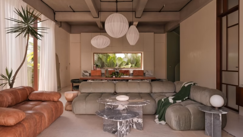 A living room with grey sofas, a marble coffee table and three white pendant lights